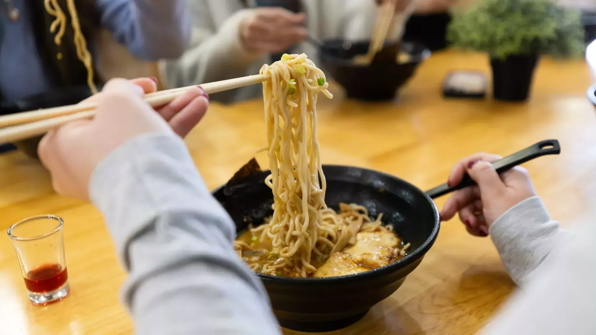 用筷子把拉面从碗里拿出来的人